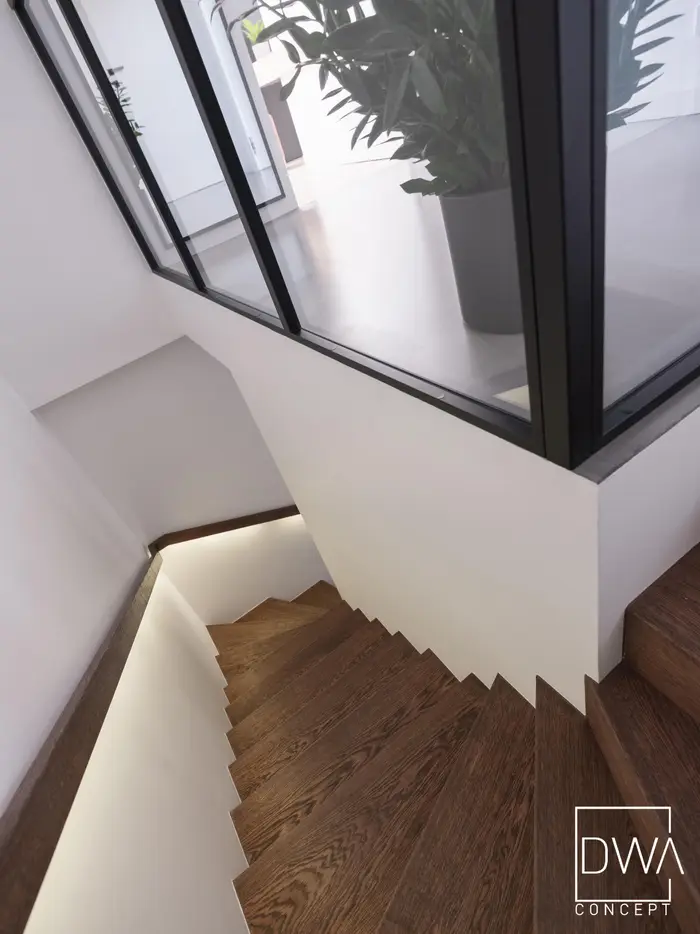 Klatka schodowa z drewnianymi stopniami i przeszkloną balustradą - dom pod Krakowem