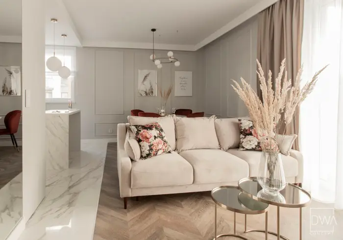 Elegancki salon z kremową sofą i marmurową posadzką - apartament 46 m2 w Krakowie