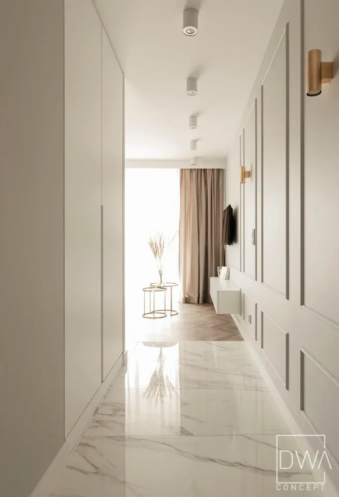 Hol z marmurową posadzką, boazerią i złotymi kinkietami - apartament 46m2 w Krakowie