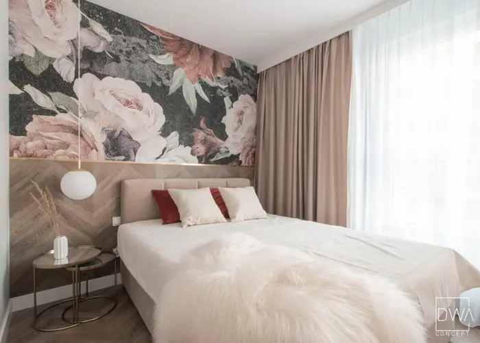 Sypialnia z kwiatową tapetą i tapicerowanym łóżkiem z poduszkami - apartament 46m2 w Krakowie