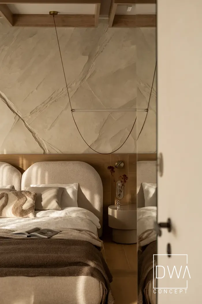 Widok na sypialnię przez uchylone drzwi z lustrzanym odbiciem - apartament w Krakowie