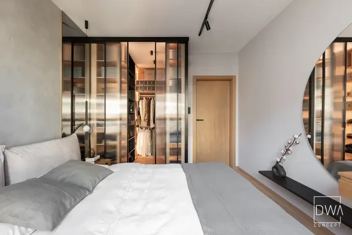 Garderoba z wieszakami na ubrania za rozsuwanymi szklanymi drzwiami - apartament w Krakowie