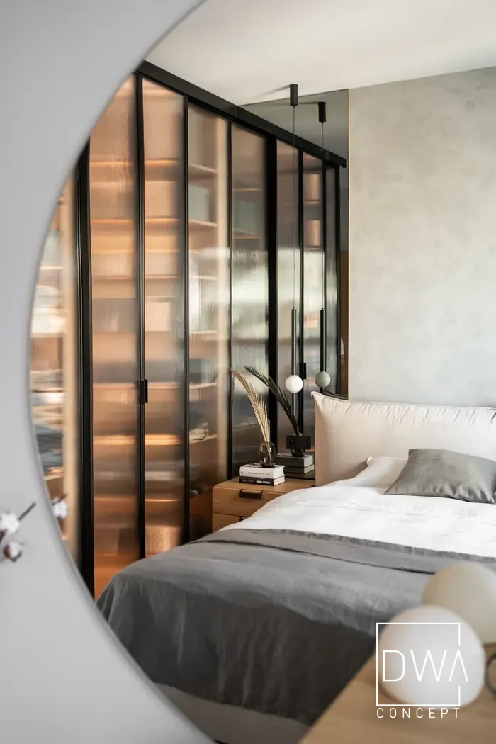 Odbicie sypialni i garderoby w okrągłym lustrze nad toaletką - apartament w Krakowie