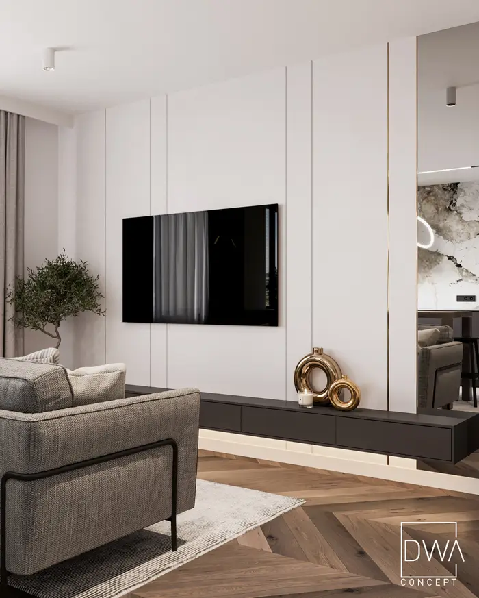 Salon z telewizorem na białej zabudowie, złotymi wazonami i drzewkiem oliwnym - apartament w Rabce-Zdroju