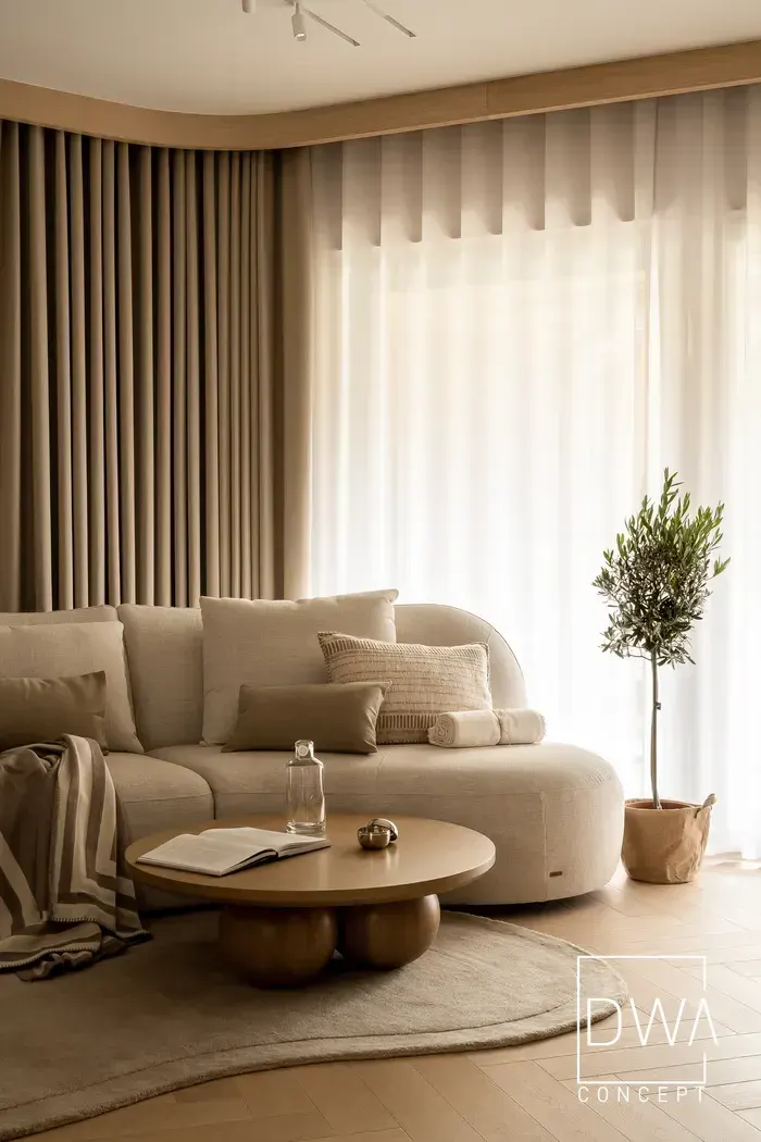 Zaokrąglona sofa w salonie z widokiem na drzewko oliwne przy oknie - apartament w Zakopanem