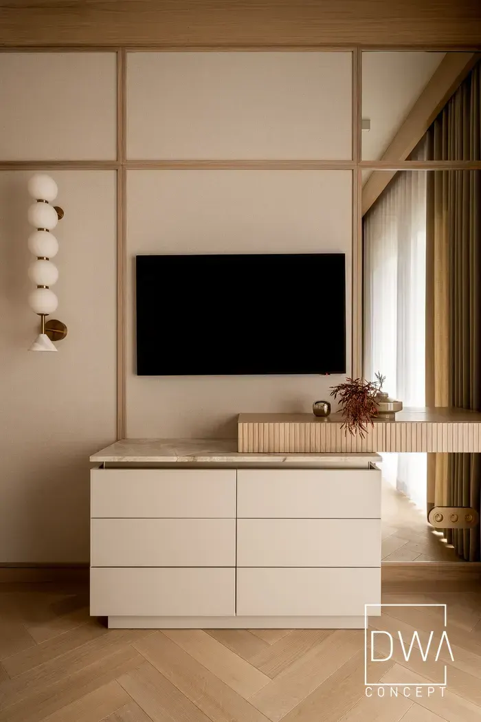 Detal komody z kulistym kinkietem i telewizorem odbitym w lustrze - apartament w Zakopanem